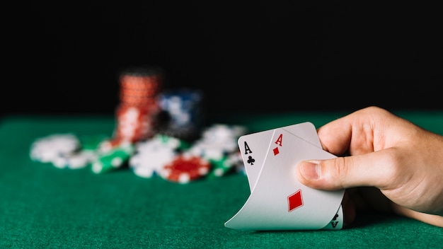 Close-up of a player holding two aces card on poker table Photo | Free ...