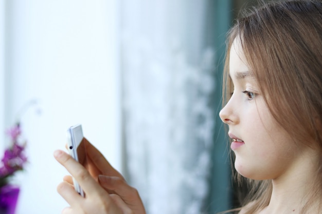 Premium Photo | Close up portrait of cute little girl looking at phone