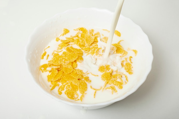 Free Photo Close Up Pouring Milk In A Bowl With Cornflakes