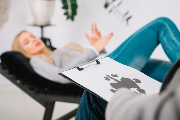 Close-up of psychologist diagnostic inkblot test rorschach of her patient lying on couch Free Photo