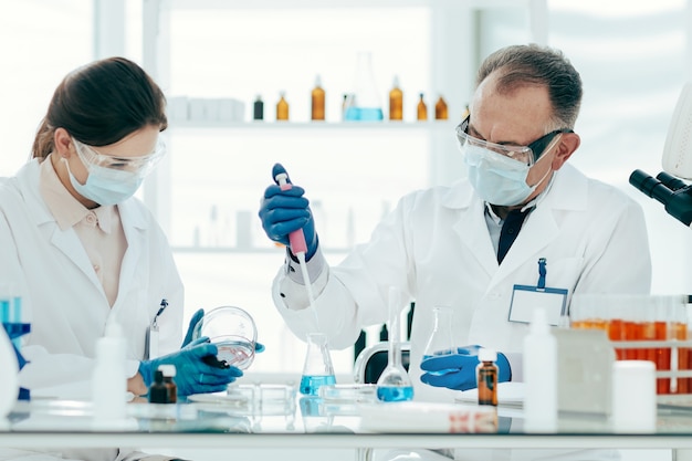 Premium Photo | Close up. scientist and laboratory assistant conduct  research in the laboratory.