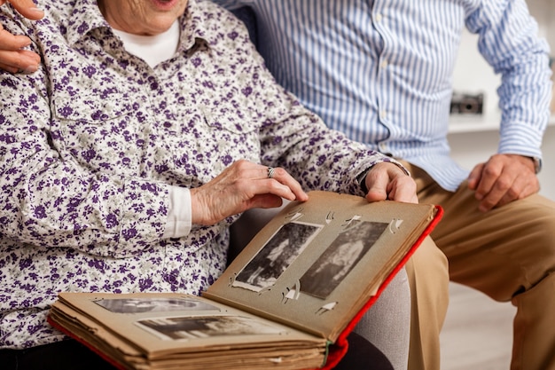 Close-up senior couple holding photo album | Free Photo