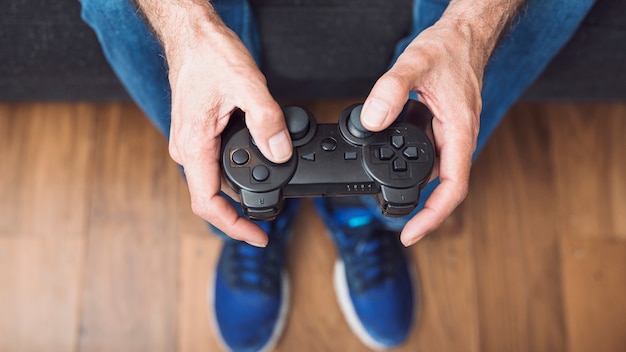 Close-up of senior man's hand holding video game console