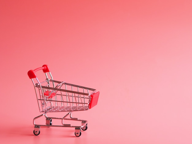 Premium Photo | Close up shopping cart over pink background,copy space.