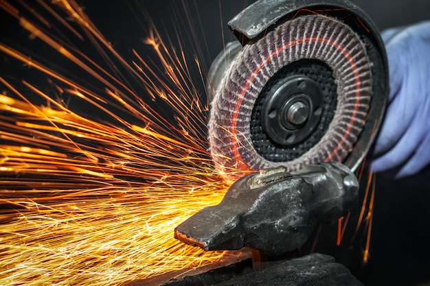 close-up-sides-fly-bright-sparks-from-angle-grinder-machine-young-male-welder-white-working-gloves-grinds-metal-product-with-angle-grinder-garage_116124-1409.jpg