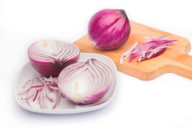 Close up of sliced red onion and whole red onion on a wooden table. Free Photo