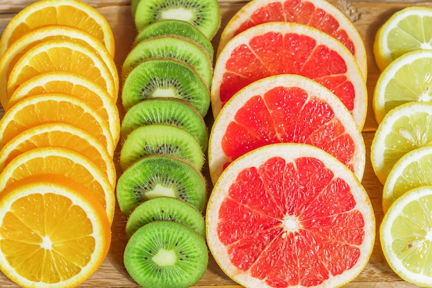 Close Up Of Slices Of Oranges Lemons Kiwi Grapefruit Pattern On Wooden Premium Photo