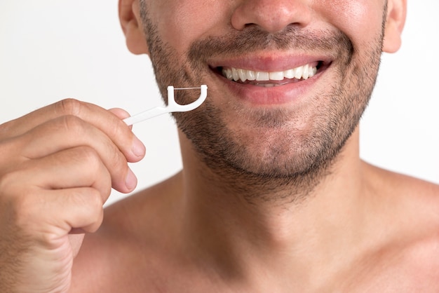 Close-up of smiling shirtless man holding floss Free Photo