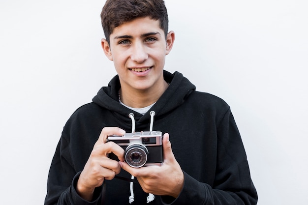 Free Photo | Close-up of smiling teenage boy holding retro camera