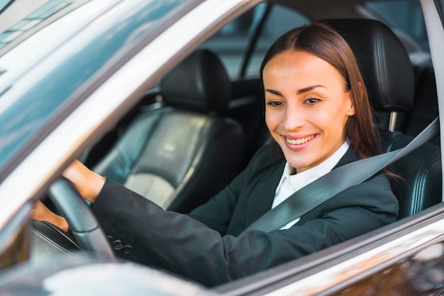 Free Photo | Close-up of a smiling young businesswoman driving a car