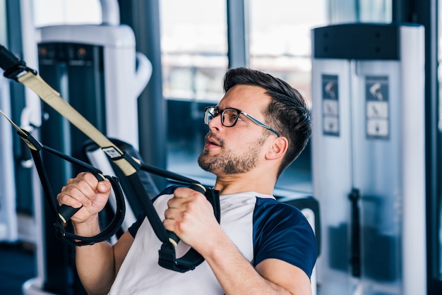 Premium Photo | Close-up of sportsman in eyeglasses working out on trx.