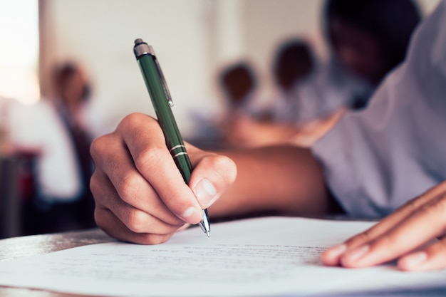 Premium Photo Close Up To Student Holding Pencil And Writing Final Exam