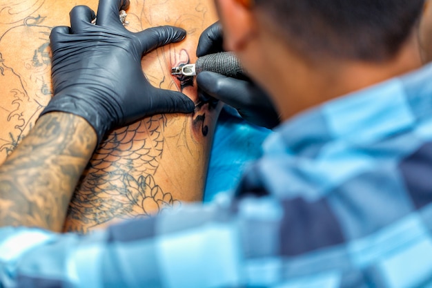 Close Up Tattoo Artist Demonstrates The Process Of Getting Black Tattoo