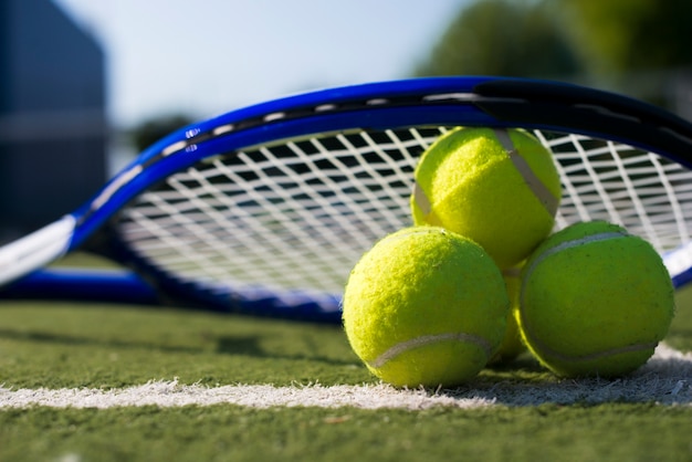 Close-up tennis rocket over balls Photo | Free Download