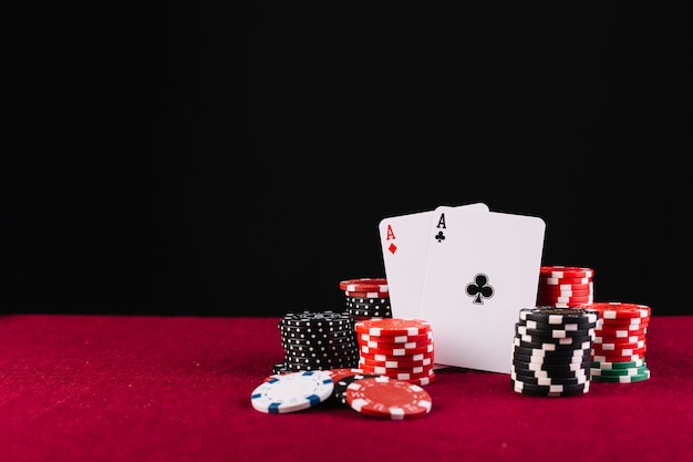 Premium Photo | Close-up of two aces playing cards and poker chips on red  background