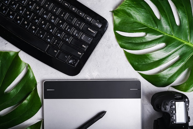 Premium Photo Close Up View Of Photographer S Of Graphic Designer S Workplace Tablet Stylus Camera Keyboard With Russian And English Letters Monstera Green Leaf