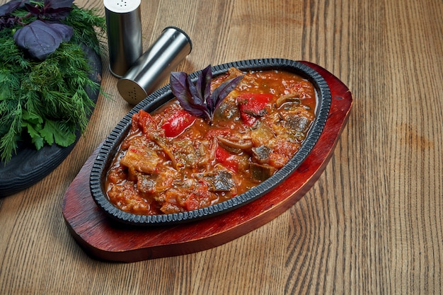 Close up view on tasty ajapsandali - vegetable stew consists of onion, eggplant, potato, tomato, bell pepper, parsley and other seasoning. traditional georgian cuisine Premium Photo