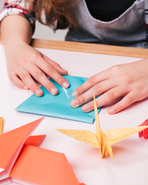 Close Up Of Woman Hand Folding Origami Paper For Making