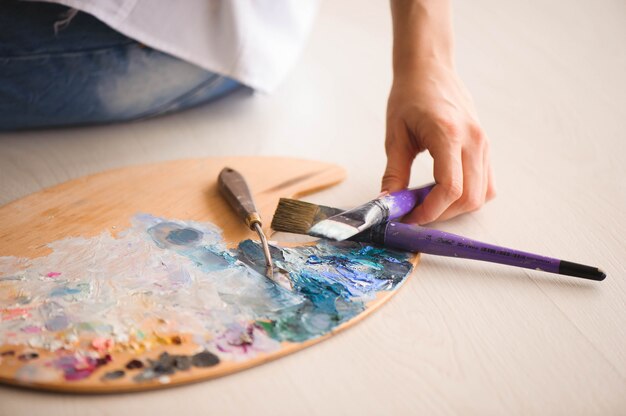 Close Up Of Woman Hand Mix Paints With Brush In Palette In Art