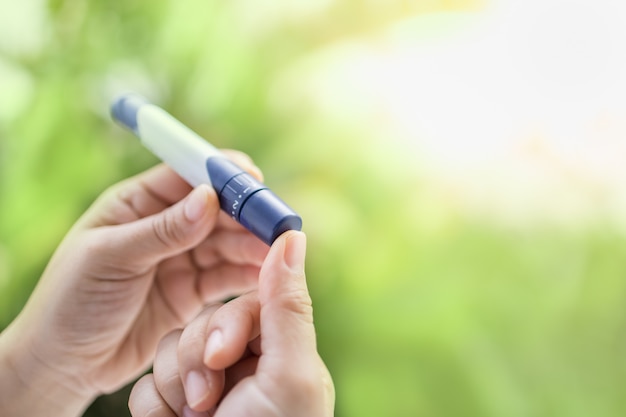 Premium Photo Close Up Of Woman Hands Using Lancet On Finger To Check Blood Sugar Level By Glucose Meter In The Morning Use As Medicine Diabetes Glycemia Health Care And People