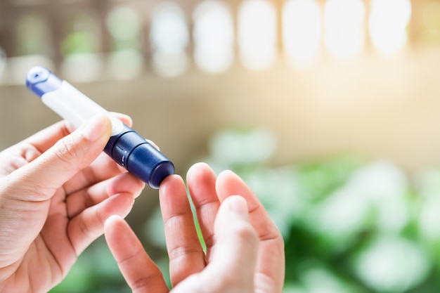 Premium Photo Close Up Of Woman Hands Using Lancet On Finger To Check Blood Sugar Level Diabetes By Glucose Meter