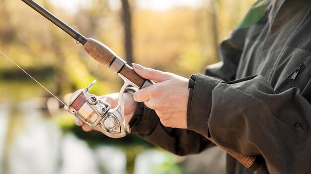 Premium Photo | Close-up of a woman holding a fishing rod with a reel ...