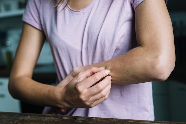 Close-up of a woman pinching her arm Free Photo