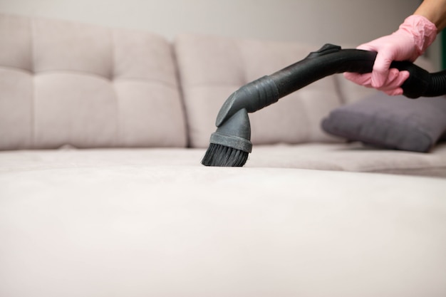 Premium Photo | Close up of woman's hand cleaning couch using vacuum ...