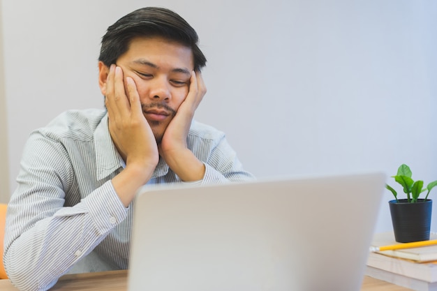 Close Up Young Asian Man Feeling Bored And Sleepy At Desk