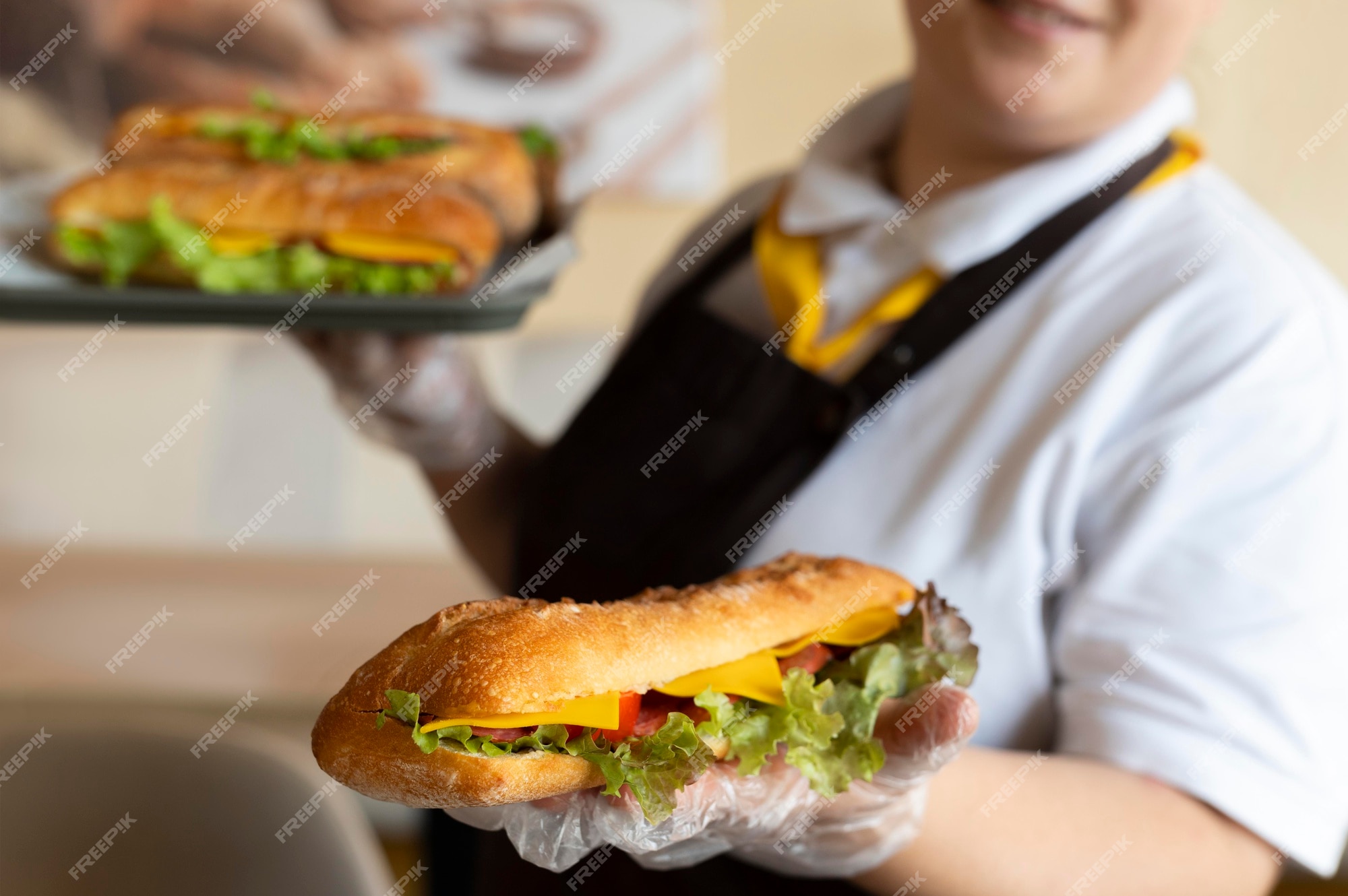 Free Photo | Close up on young chef holding sandwiches