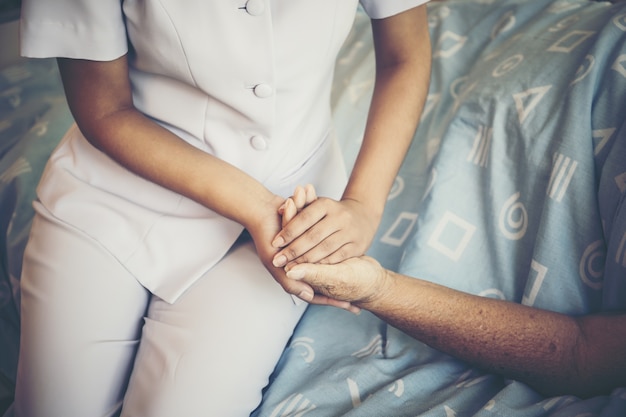 Close Up Of Young Nurse Take Care For Elderly Patients Holding Her