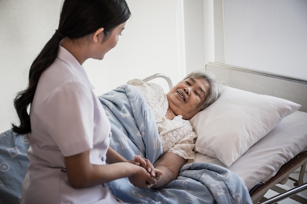 Close Up Of Young Nurse Take Care For Elderly Patients Holding Her