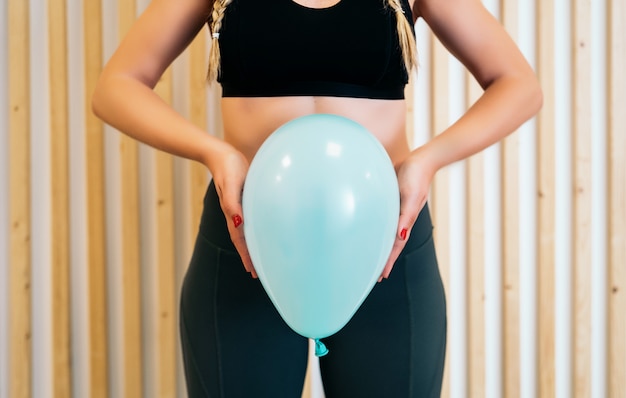 A woman holding a balloon representing the pelvic floor muscles in north vancouver