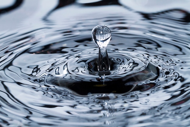 Premium Photo | Close view of a droplet of water hitting a surface of ...