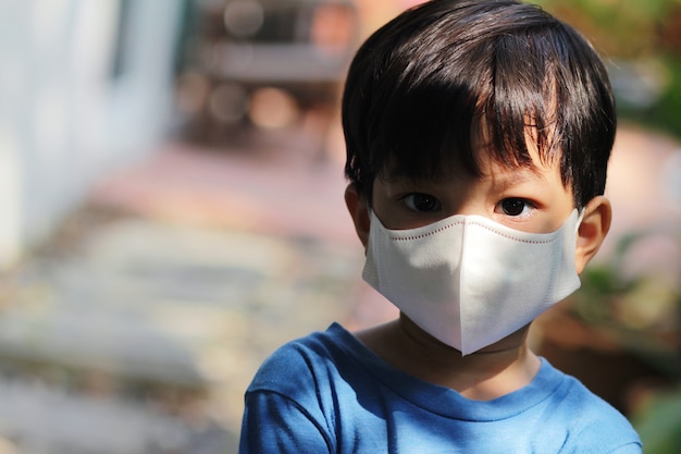 Premium Photo | Closed up head shot of kid wearing mask. asian little ...