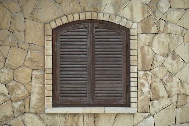 Closed window in a stone wall Free Photo