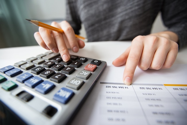 Closeup of accountant hands counting on calculator Free Photo