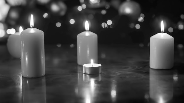 Premium Photo | Closeup black and white image of burning candles on ...