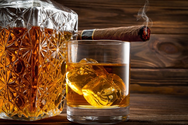 Closeup of bottle, glass with whiskey and smoldering cigar Premium Photo
