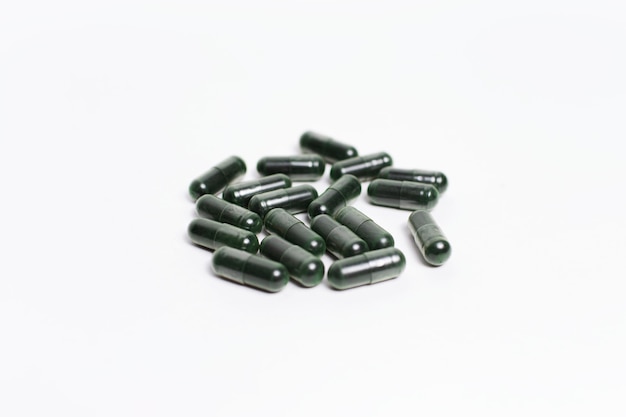 premium-photo-closeup-of-dark-green-capsule-pills-isolated-on-white