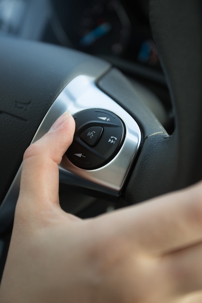 Premium Photo | Closeup of driver using control panel on steering wheel