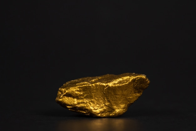 Premium Photo | Closeup of gold nugget or gold ore on black background