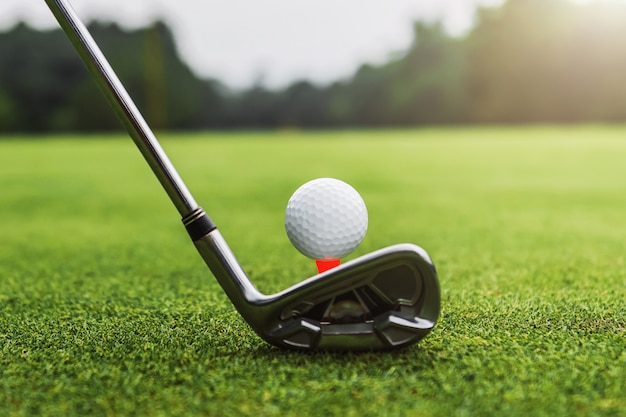 Premium Photo Closeup golf club and golf ball on green grass wiht sunset