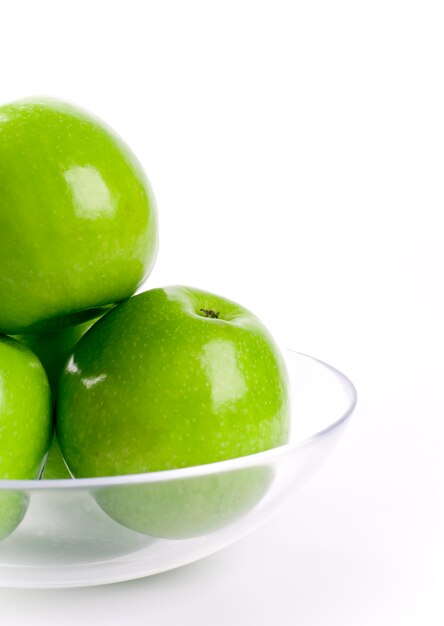 Premium Photo | Closeup of green apples in glass bowl on white background