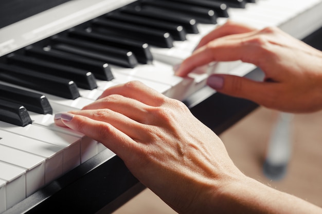 Premium Photo | Closeup of hands playing piano. music and hobby concept