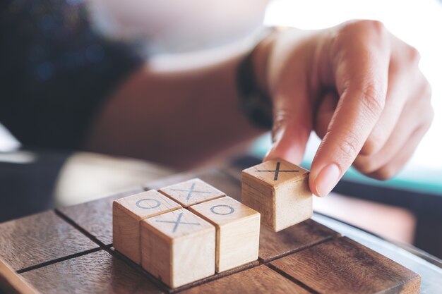 Premium Photo | Closeup image of people playing wooden tic tac toe game ...