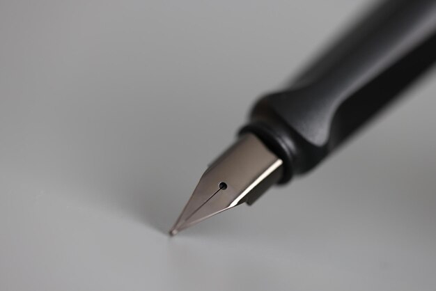 Premium Photo | Closeup of metal ink pen head on gray background ...