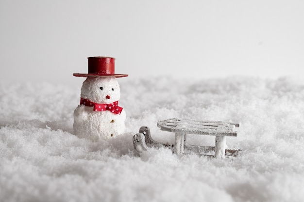 かわいい雪だるまのおもちゃと雪の中のそりのクローズアップ 無料の写真