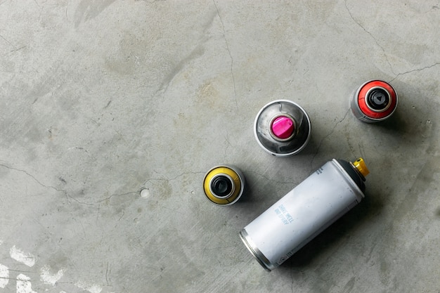 Premium Photo | Closeup old cans of spray paint on cement floor