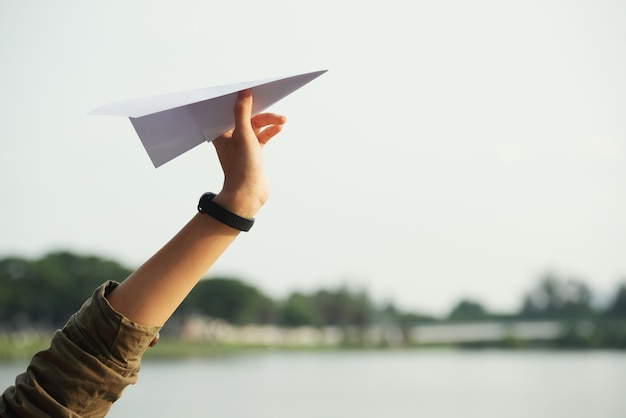 Free Photo | Closeup of a teenage hand throwing the paper plane